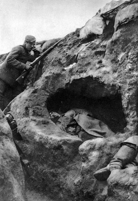 Niemcy pod Arras w 1914 roku. Nerwowo paląc papierosa, z karabinem w dłoni, stale spoglądając w kierunku pozycji przeciwnika, niemiecki żołnierz umożliwia krótki odpoczynek swym kolegom. Śpią oni w wygrzebanych we frontowej ścianie okopu 'norach tchórza', gotowi zerwać się do walki w razie ataku. Niemcy pod Arras w 1914 roku. Nerwowo paląc papierosa, z karabinem w dłoni, stale spoglądając w kierunku pozycji przeciwnika, niemiecki żołnierz umożliwia krótki odpoczynek swym kolegom. Śpią oni w wygrzebanych we frontowej ścianie okopu 'norach tchórza', gotowi zerwać się do walki w razie ataku.