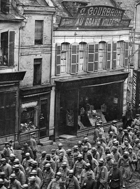 Kolumna francuskich jeńców na ulicach Saint-Quentin wiosną 1918 roku. Ogromne ilości żołnierzy dostawały się do niewoli nawet w ostatnich miesiącach walk. W wyniku podjętej 21 marca 1918 roku ofensywy na Froncie Zachodnim, w okolicach Saint-Quentin, Niemcy wzięli 90 tysięcy jeńców. Długie kolumny ciągnęły na zachód ulicami francuskich miast, mając przypominać ich mieszkańcom, że losy wojny jeszcze się ostatecznie nie rozstrzygnęły. Zwracają uwagę puste okna i obecność jedynie samych Niemców na ulicach - tak, jakby Francuzi nie chcieli w żaden sposób, nawet jako widzowie, uczestniczyć w tej upokarzającej manifestacji. Kolumna francuskich jeńców na ulicach Saint-Quentin wiosną 1918 roku. Ogromne ilości żołnierzy dostawały się do niewoli nawet w ostatnich miesiącach walk. W wyniku podjętej 21 marca 1918 roku ofensywy na Froncie Zachodnim, w okolicach Saint-Quentin, Niemcy wzięli 90 tysięcy jeńców. Długie kolumny ciągnęły na zachód ulicami francuskich miast, mając przypominać ich mieszkańcom, że losy wojny jeszcze się ostatecznie nie rozstrzygnęły. Zwracają uwagę puste okna i obecność jedynie samych Niemców na ulicach - tak, jakby Francuzi nie chcieli w żaden sposób, nawet jako widzowie, uczestniczyć w tej upokarzającej manifestacji.