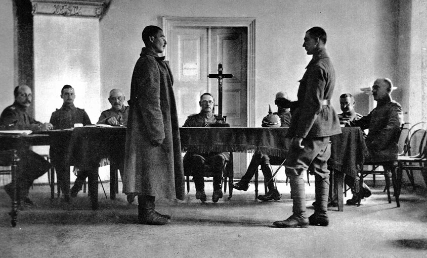 Rosyjski szpieg przed niemieckim sądem wojskowym. Jedną z cech Wielkiej Wojny jako wojny totalnej było uruchomienie przez walczące strony gigantycznego aparatu propagandowego. 'Wojna psychologiczna', jak ją nazwał prof. Jerzy Holzer, służyć miała podtrzymaniu morale żołnierzy i obywateli oraz zohydzeniu, w oczach własnego społeczeństwa, wizerunku przeciwnika. Nękano również bezpośrednio wrogów, chcąc osłabić ich wolę walki. Poważnym problemem było wyjaśnienie obywatelom przyczyn przedłużania się konfliktu i ponoszenia klęsk. Stąd też jednym z motywów, powracających w propagandzie wojennej, była sugestia, jakoby szczególną aktywność rozwijali spiskowcy i tajni agenci. Jakie rozmiary przybierało polowanie na szpiegów, łatwo uzmysłowić sobie na podstawie losów Dobrego Wojaka Szwejka z powieści Jaroslava Haszka. W okresie międzywojennym zakorzenione dość powszechnie przeświadczenie o istnieniu rzekomego, tajemnego porozumienia wrogich sił ułatwiało manipulowanie nastrojami społeczeństw. Wynajdywanie wspólnego wroga legło u genezy ruchów totalitarnych. Zwłaszcza Niemcy, nie mogący się pogodzić ze skutkami wojny, przyjęli nazistowską tezę o ciosie wymierzonym w plecy. Rosyjski szpieg przed niemieckim sądem wojskowym. Jedną z cech Wielkiej Wojny jako wojny totalnej było uruchomienie przez walczące strony gigantycznego aparatu propagandowego. 'Wojna psychologiczna', jak ją nazwał prof. Jerzy Holzer, służyć miała podtrzymaniu morale żołnierzy i obywateli oraz zohydzeniu, w oczach własnego społeczeństwa, wizerunku przeciwnika. Nękano również bezpośrednio wrogów, chcąc osłabić ich wolę walki. Poważnym problemem było wyjaśnienie obywatelom przyczyn przedłużania się konfliktu i ponoszenia klęsk. Stąd też jednym z motywów, powracających w propagandzie wojennej, była sugestia, jakoby szczególną aktywność rozwijali spiskowcy i tajni agenci. Jakie rozmiary przybierało polowanie na szpiegów, łatwo uzmysłowić sobie na podstawie losów Dobrego Wojaka Szwejka z powieści Jaroslava Haszka. W okresie międzywojennym zakorzenione dość powszechnie przeświadczenie o istnieniu rzekomego, tajemnego porozumienia wrogich sił ułatwiało manipulowanie nastrojami społeczeństw. Wynajdywanie wspólnego wroga legło u genezy ruchów totalitarnych. Zwłaszcza Niemcy, nie mogący się pogodzić ze skutkami wojny, przyjęli nazistowską tezę o ciosie wymierzonym w plecy.
